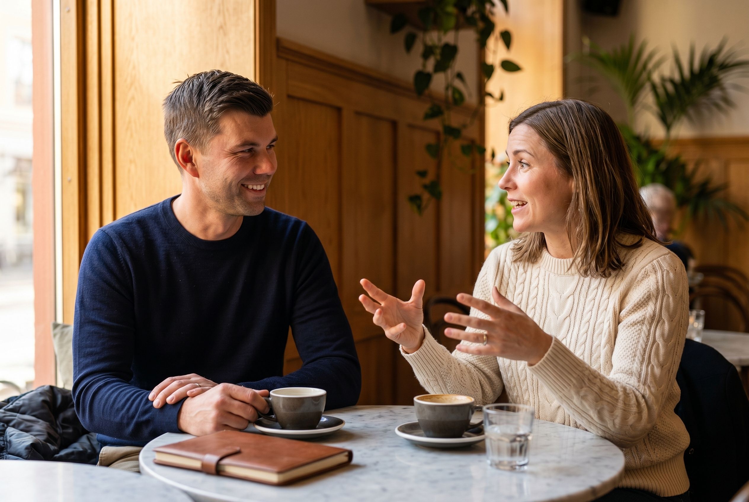 Rasmus Eriksson lyssnar uppmärksamt på en senior IT-konsult i ett ljust café i Göteborg — ett bollplankssamtal i karriärrådgivning.